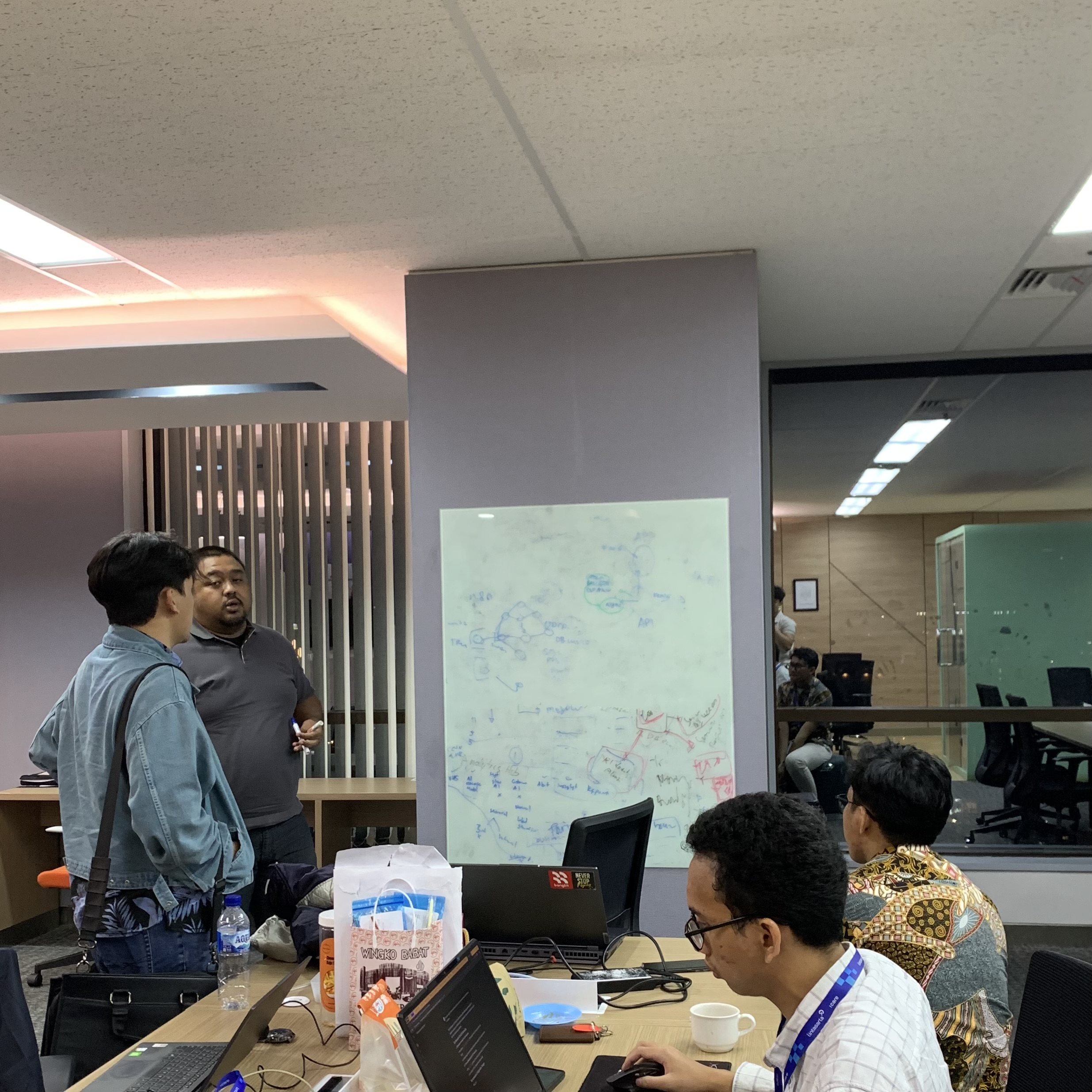 A discussion around a whiteboard and laptops at the Lintasarta office